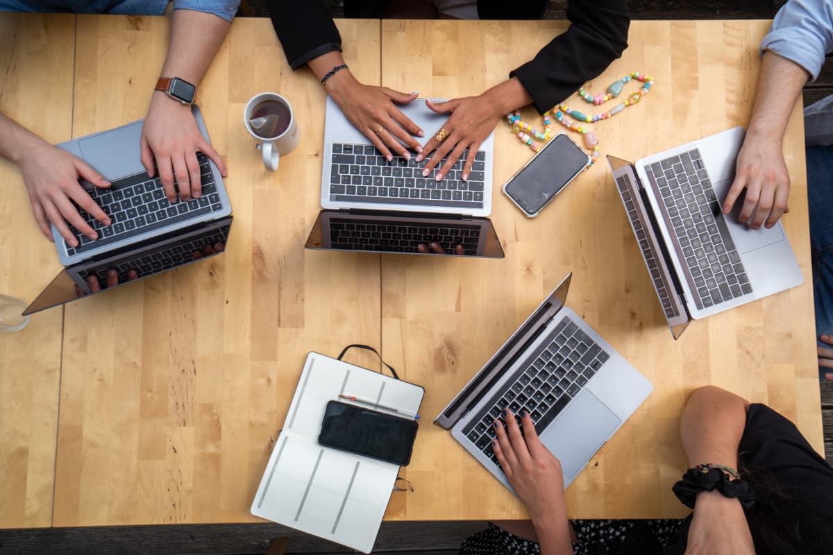 Hands on laptops on a table