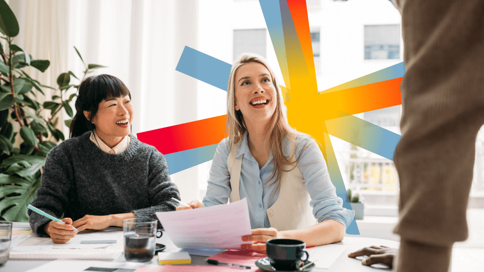 Two women laughing while working